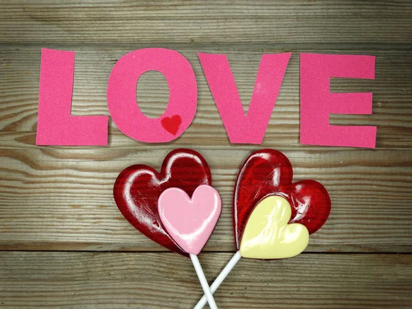 ハートのロリポップ甘い愛バレンタインデーの木製の背景 — ストック写真