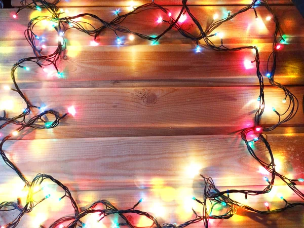 Різдвяні гірлянди на дерев'яному фоні — стокове фото
