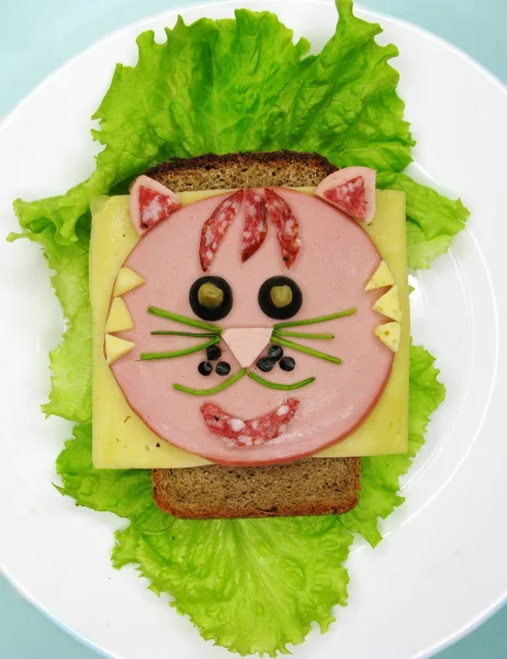 creative food sandwich with sausage and cheese served on lettuce