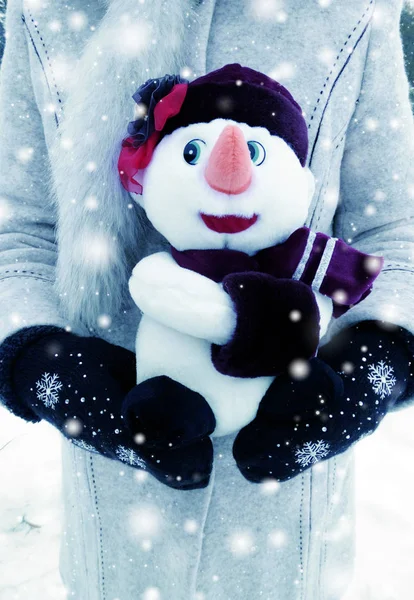 Bonhomme de neige jouet dans les mains de la femme avec neige — Photo