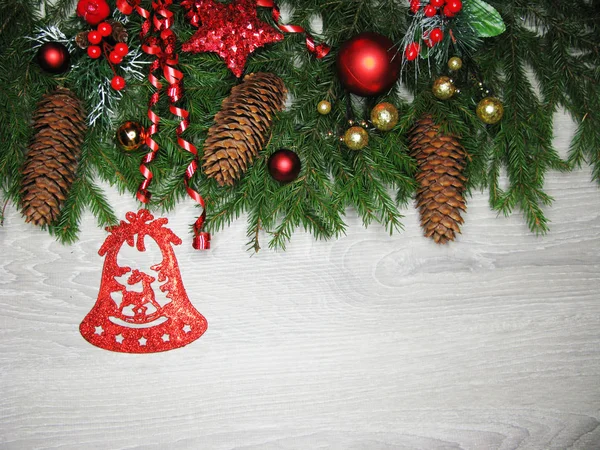 Conos de decoración de Navidad y luces de guirnalda en el fondo de madera — Foto de Stock