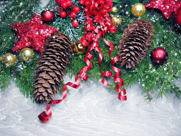 Conos de decoración de Navidad y luces de guirnalda en el fondo de madera — Foto de Stock