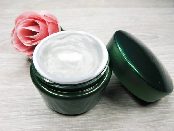 Crema cosmética para el cuidado de la cara y flores de rosas — Foto de Stock