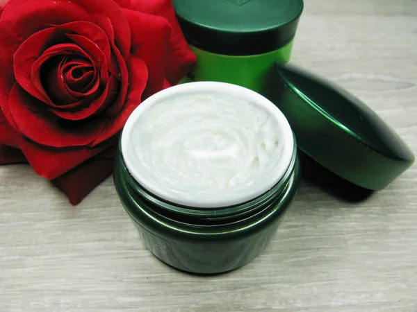 Cosmetische crème voor gezichts onderhoud en roze bloemen — Stockfoto