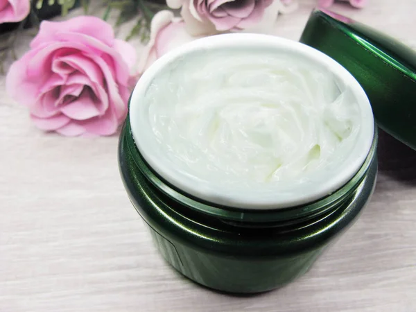 Crema cosmética para el cuidado de la cara y flores de rosas —  Fotos de Stock