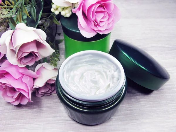 Crème cosmétique pour soins du visage et fleurs roses — Photo