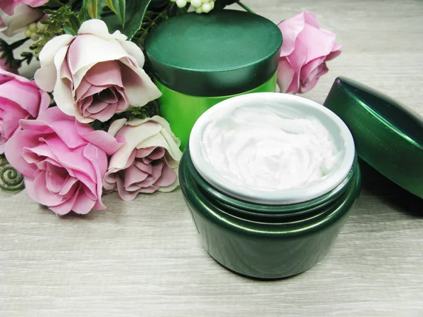 Crema cosmética para el cuidado de la cara y flores de rosas —  Fotos de Stock