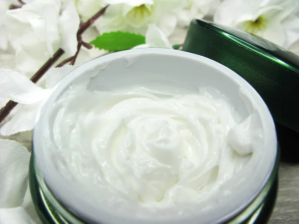 Cosmetic cream for face care and white sakura flowers Stock Image
