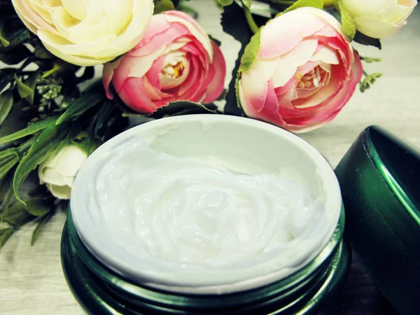 Crema cosmética para el cuidado de la cara y flores de rosas —  Fotos de Stock