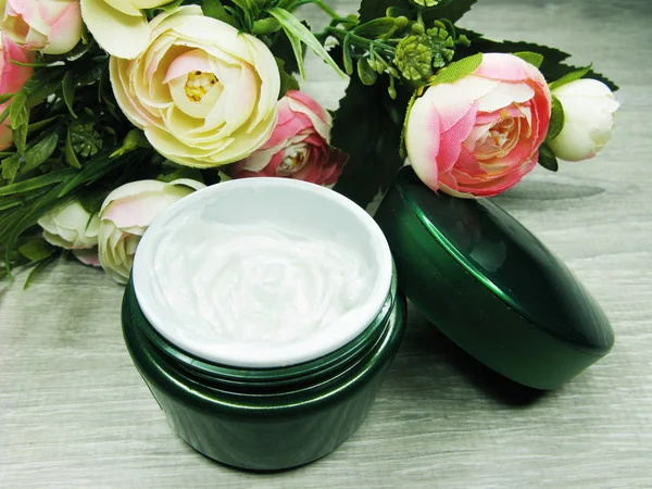 Cosmetische crème voor gezichts onderhoud en roze bloemen — Stockfoto