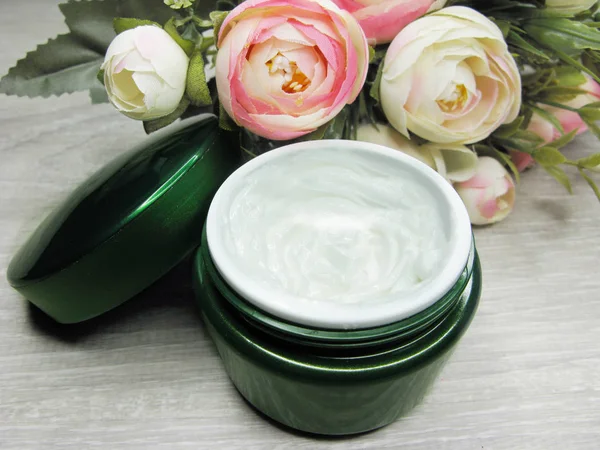 Crème cosmétique pour soins du visage et fleurs roses — Photo