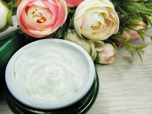 Crème cosmétique pour soins du visage et fleurs roses — Photo