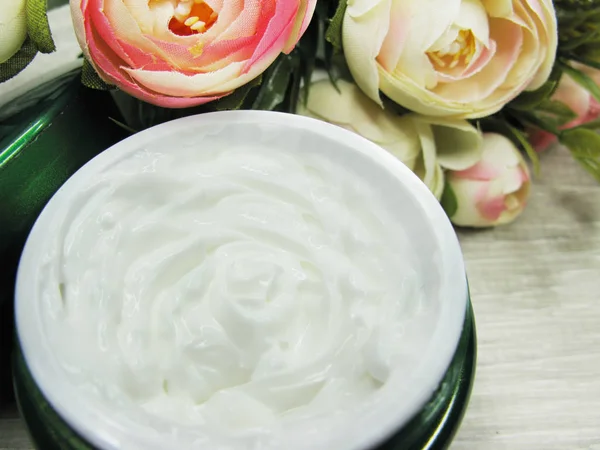 Косметический крем для ухода за лицом и цветами роз — стоковое фото