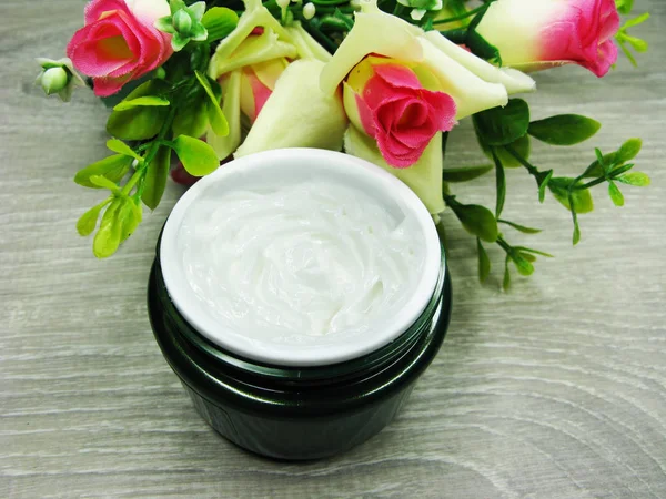 Crème cosmétique pour soins du visage et fleurs roses — Photo