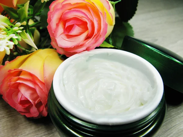 Crema cosmetica per la cura del viso e fiori di rosa — Foto Stock