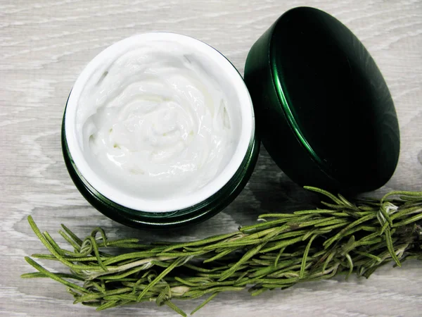 Crema cosmética para el cuidado de la cara y hojas de romero —  Fotos de Stock