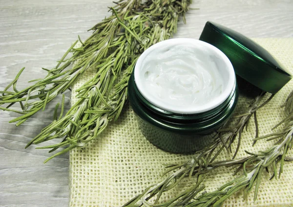 Crema cosmetica per la cura del viso e foglie di rosmarino — Foto Stock