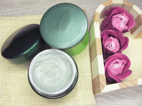 Kosmetický krém pro péči o obličej a květy růže — Stock fotografie