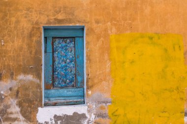 Duvar yapı sarı, mavi pencere vitray film. Boyalı grafiti. 