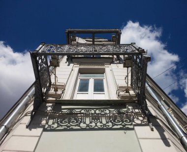 Köşe cephe bina. Ajur balkon olmadan bir yere dökme demir kafesler. Aşağıdan yukarıya görüntülemek.