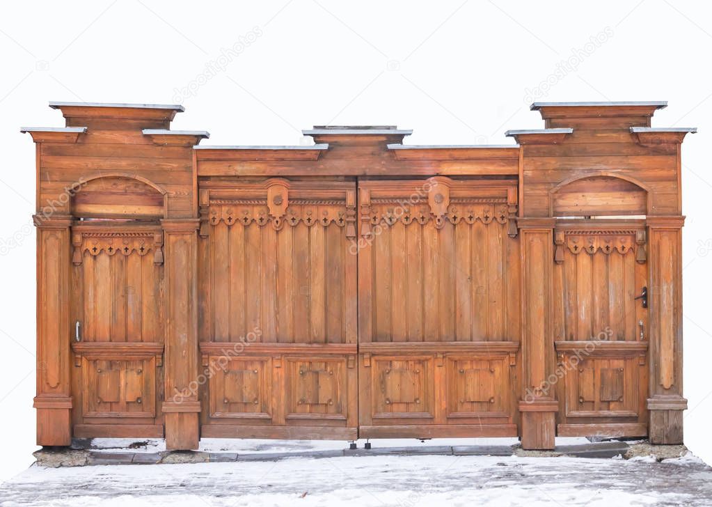 Old wooden carved gates covered with snow