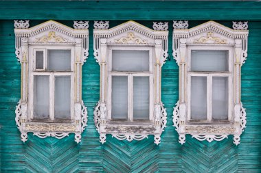 Yeşil bir ahşap evin cephe boyalı. Üç windows beyaz dekoratif Ahşap oyma kare ile. Frost'un üzerinde windows... Rus Halk tarzı. Önden Görünümü Kapat.