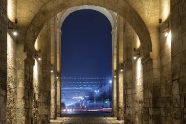 Eski sarı bir taş kemerden mavi şehrin alacakaranlık manzarası
