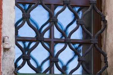 Pencere camına yansıyan eski demir ızgara.            