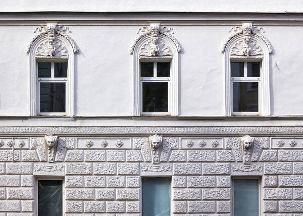 Beautiful facade of a white building with stucco antique architectural decorations front view close up