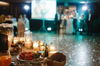 Düğündeki süslü masalarda yanan mumlar.