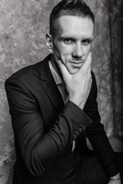 Takım elbiseli bir adamın siyah beyaz portresi.