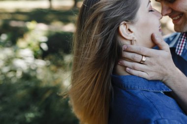 Erkek kadının yüzüne dokunur ve ona gülümser.