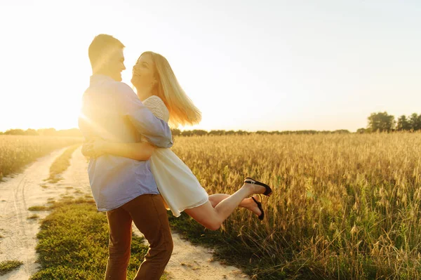 Joven sosteniendo a su mujer en las manos en el campo —  Fotos de Stock