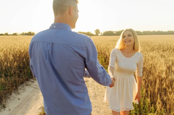 Pareja enamorada tomándose de las manos y de pie en el campo —  Fotos de Stock