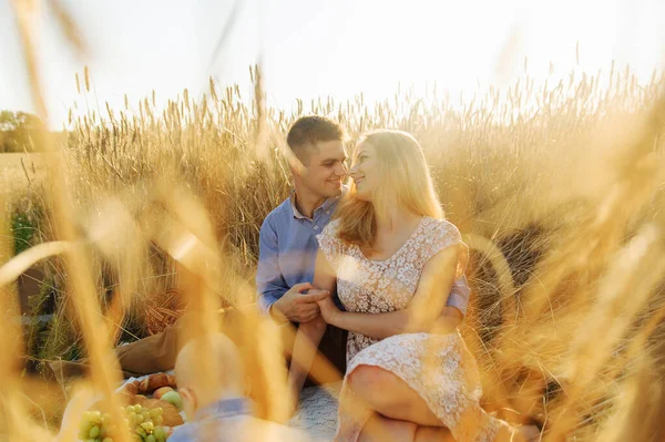 Jeune couple assis dans le champ de blé — Photo