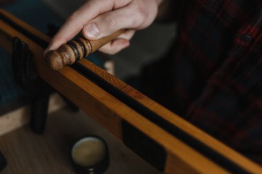 Erkek adam, üstten çekilen özel bir aletle deriyi yumuşatıyor.