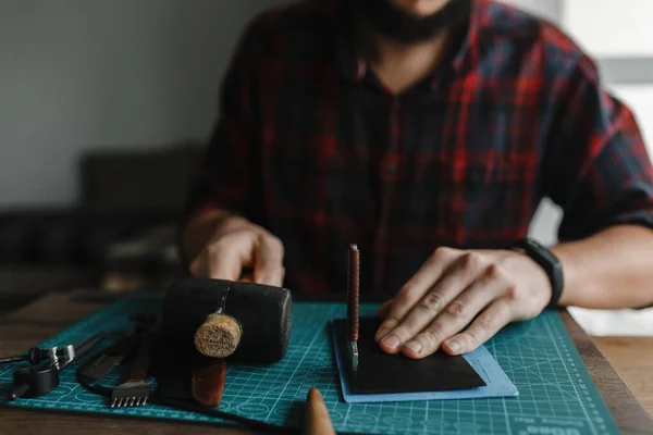Mãos de homem na mesa com os instrumentos para artesanato de couro com o espaço para o seu texto — Fotografia de Stock