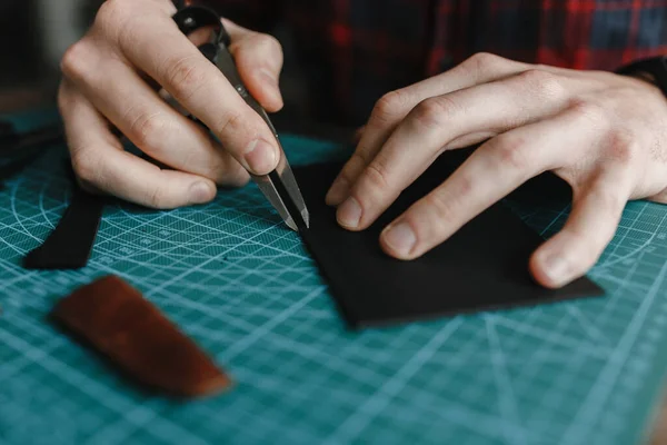 Mann hält Spezialwerkzeug in der Hand, um Brieftasche aus Leder zu machen — Stockfoto