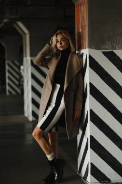 Siyah beyaz çizgilerle duvara yaslanan genç bir kadın. Kadın portresi