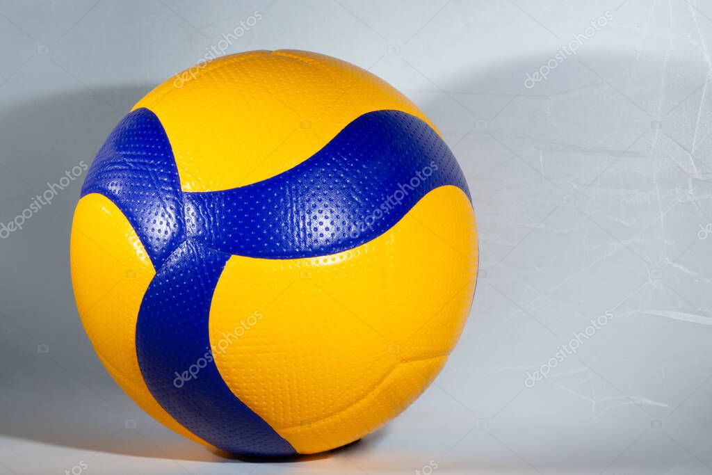 Blue and yellow ball for playing volleyball on the white background. Go in for sport