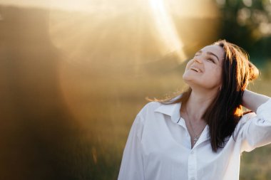 Güneşin altında durup gülümseyen bir kadın. Kadın portresi