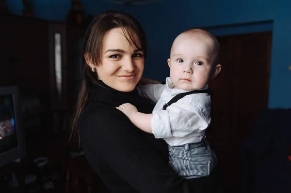 Young smiling mother holding little son in her arms — Stock Photo, Image