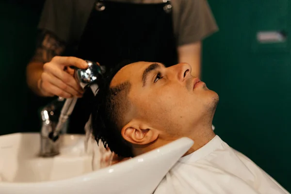 Muž myje hlavu v holičství. Příprava ženicha — Stock fotografie