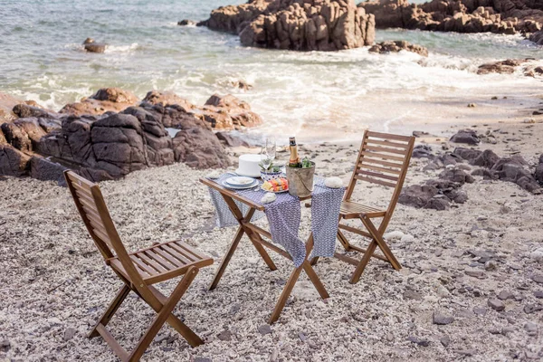 Romantisk middag som angetts för par på klippstrand — Stockfoto