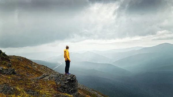 Человек стоит на холме под дождем — стоковое фото