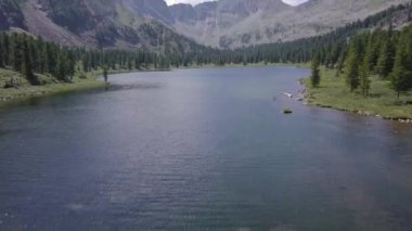 Adam yazın bir dağ gölünde banyo yapıyor.