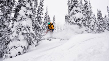 Bir snowboardcu uçar, trambolinde kar treninde zıplar.