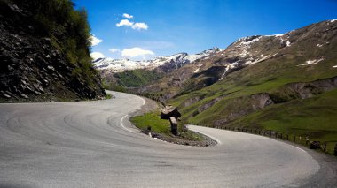 Yol yılan gibi, yeşil çayırlar ve kardan oluşan geniş bir dönüş açısı var.