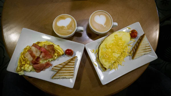 two scrambled eggs with bacon and coffee
