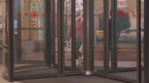 Kobieta wchodzi przez obrotowe drzwi do centrum handlowego. — Wideo stockowe